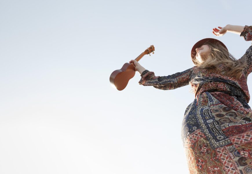 Low angle bohemian woman with ukulele copy space