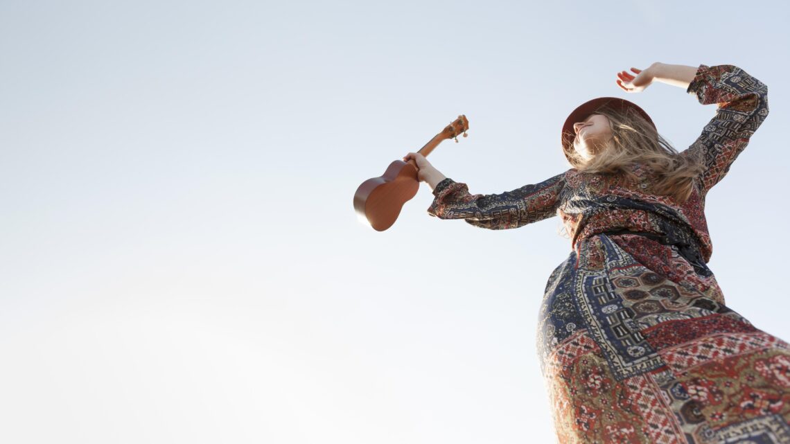 Low angle bohemian woman with ukulele copy space